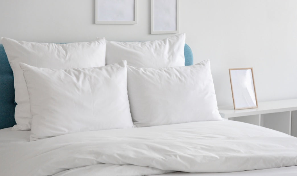 pillows and a comforter on a blue bed