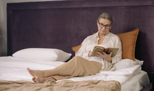 old woman reading in bed