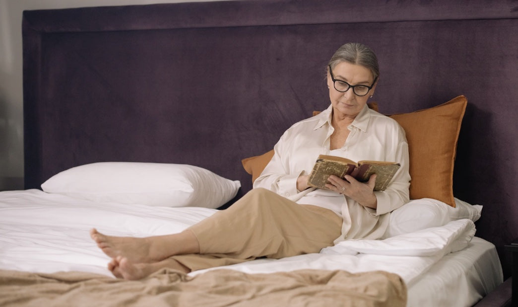 old woman reading in bed