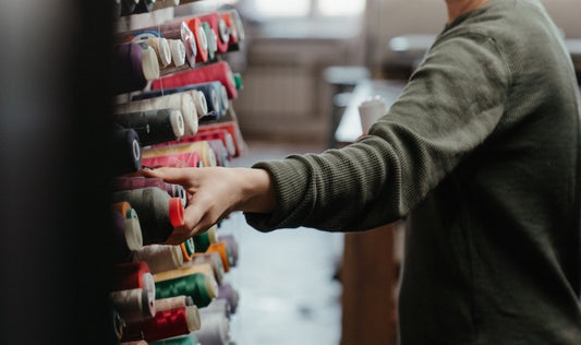 woman choosing from colorful threads