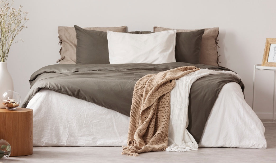 bed with neutral throw pillows and blankets