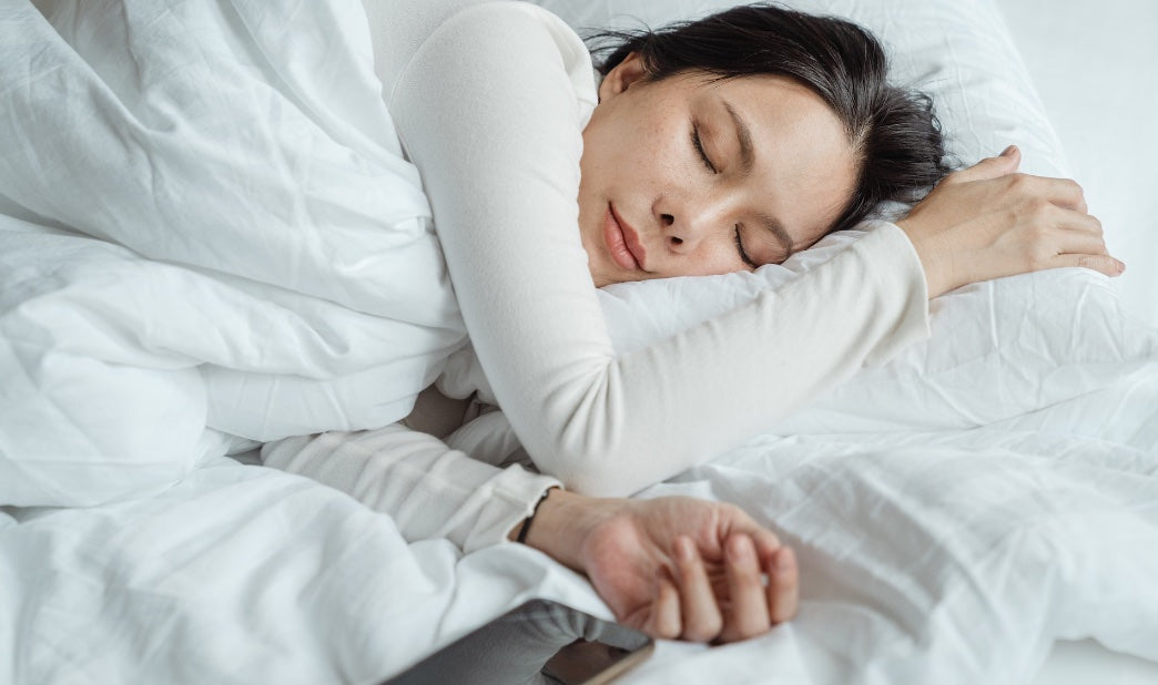 woman sleeping calmly with phone next to her