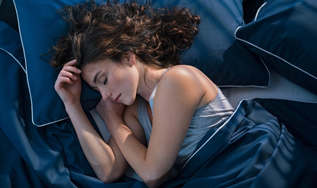 woman sleeping peacefully in blue luxury bedding
