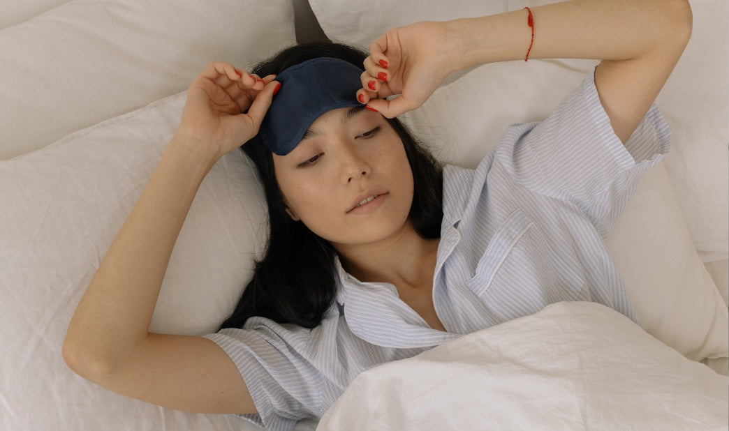 woman with an eye mask struggling to sleep