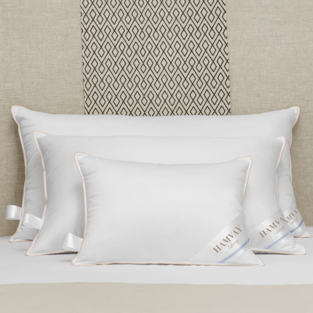 3 white down pillows on a bed