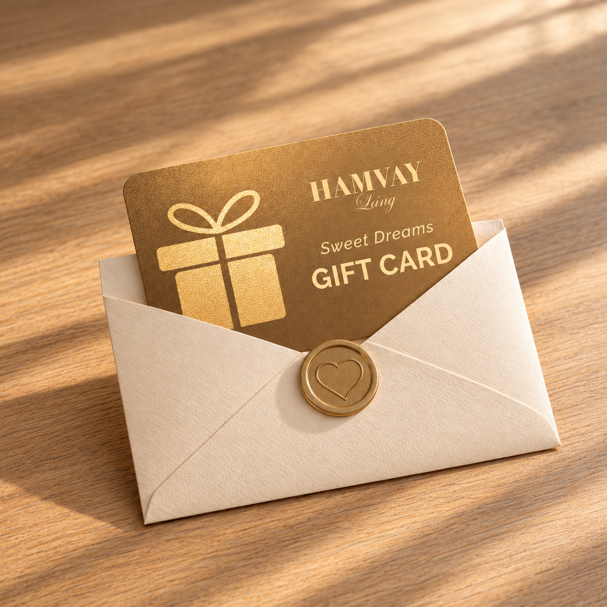 A gold gift card partially tucked into a cream-colored envelope on a wooden surface with soft shadows.