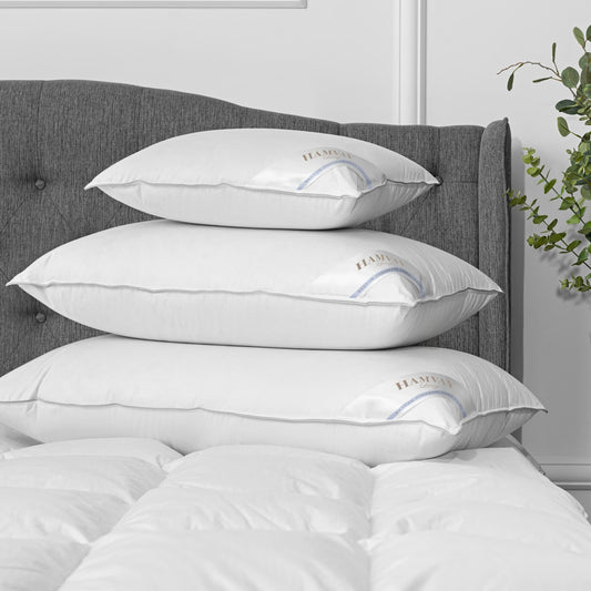 3 sizes of luxurious Hungarian goose down pillows on top of each other on a bed