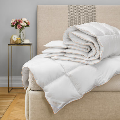 Luxurious Hungarian goose down comforter losely folded on a beige bed