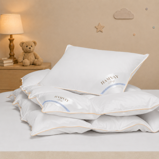 White Hamvay-Láng plush pillow on a bed in a softly lit bedroom setting with a lamp, teddy bear, and wall decorations.