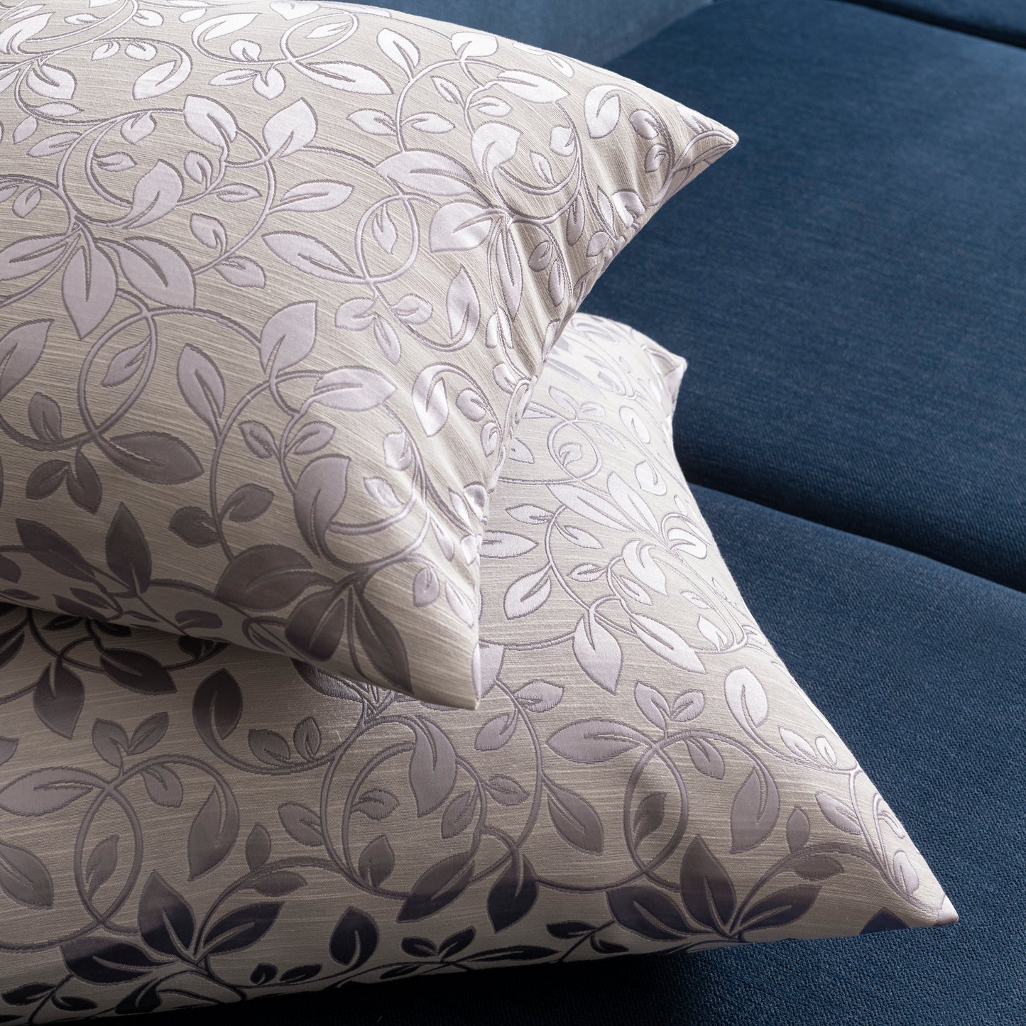 2 purple floral decorative pillows placed on top of each other